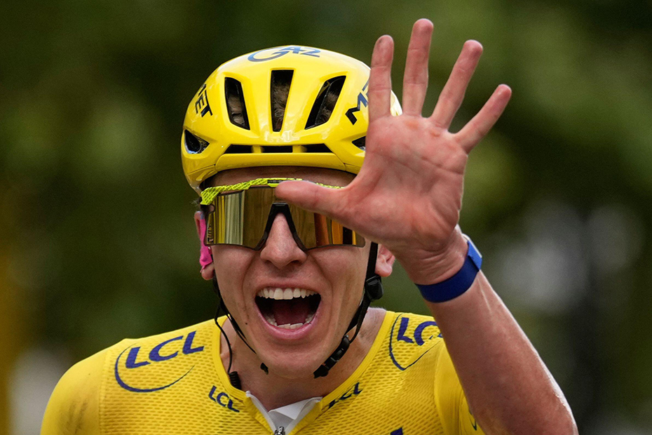 Slovenia's Tadej Pogacar, wearing the overall leader's yellow jersey, celebrates as he crosses the finish line of the last stage of the Tour de France cycling race with start and finish in Paris